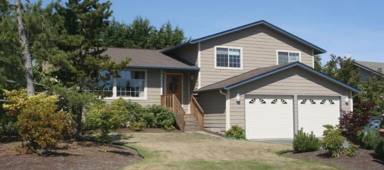 Two-story suburban home with beige siding and a well-maintained lawn