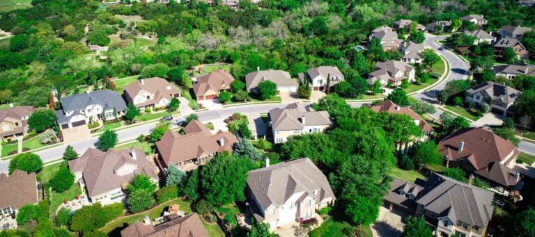 Aerial view of a suburban neighborhood with large homes and tree-lined streets