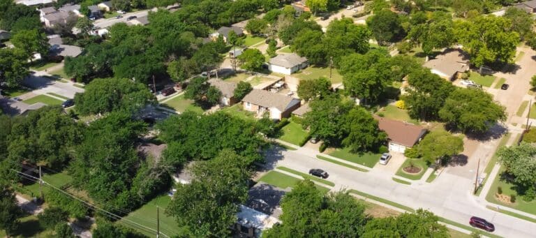 Aerial view of a quiet suburban neighborhood with tree-lined streets and single-family homes