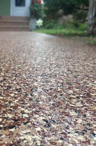 Close-up of a decorative, textured driveway surface leading to a house