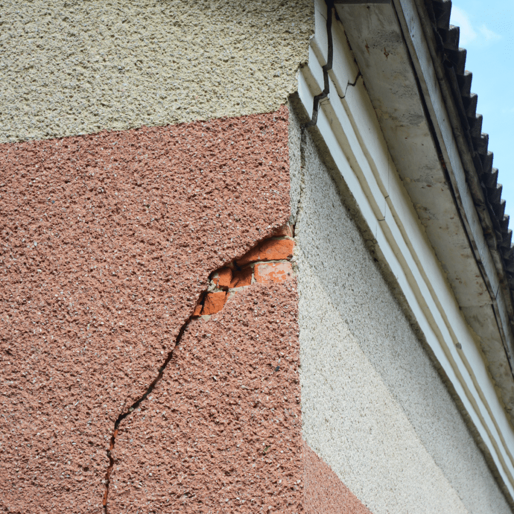 closeup of cracked and chipped stucco on the corner of a san antonio home