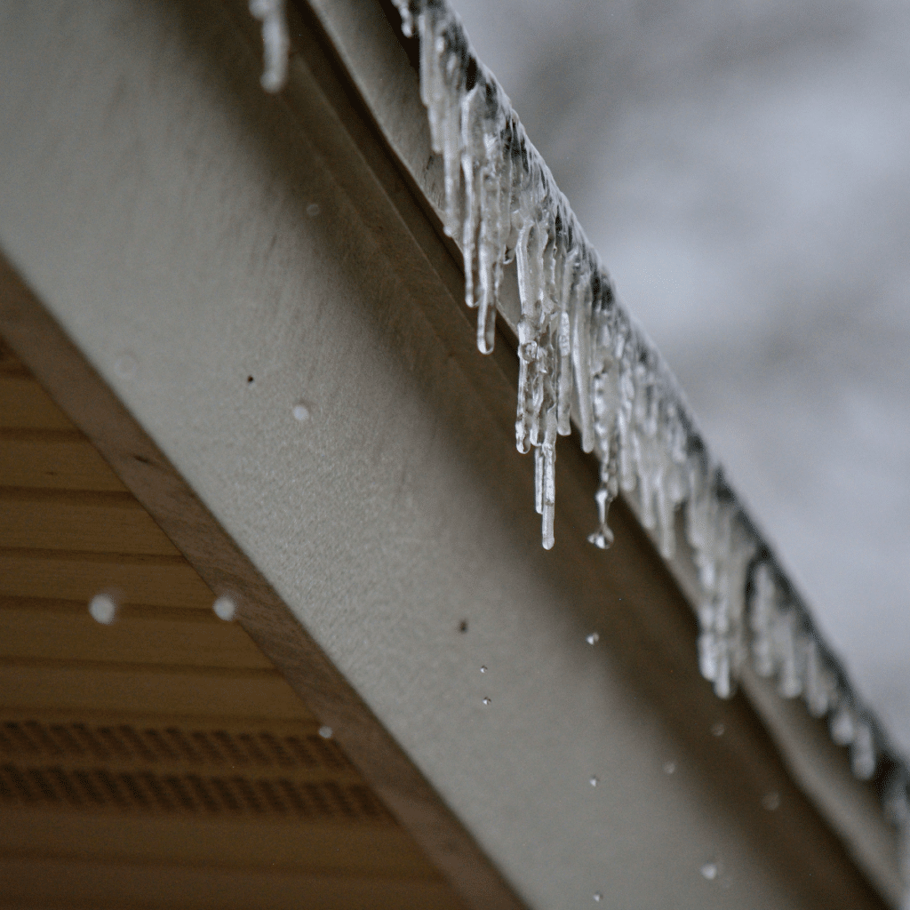 Icicles forming along the edge of a roof during cold winter weather.