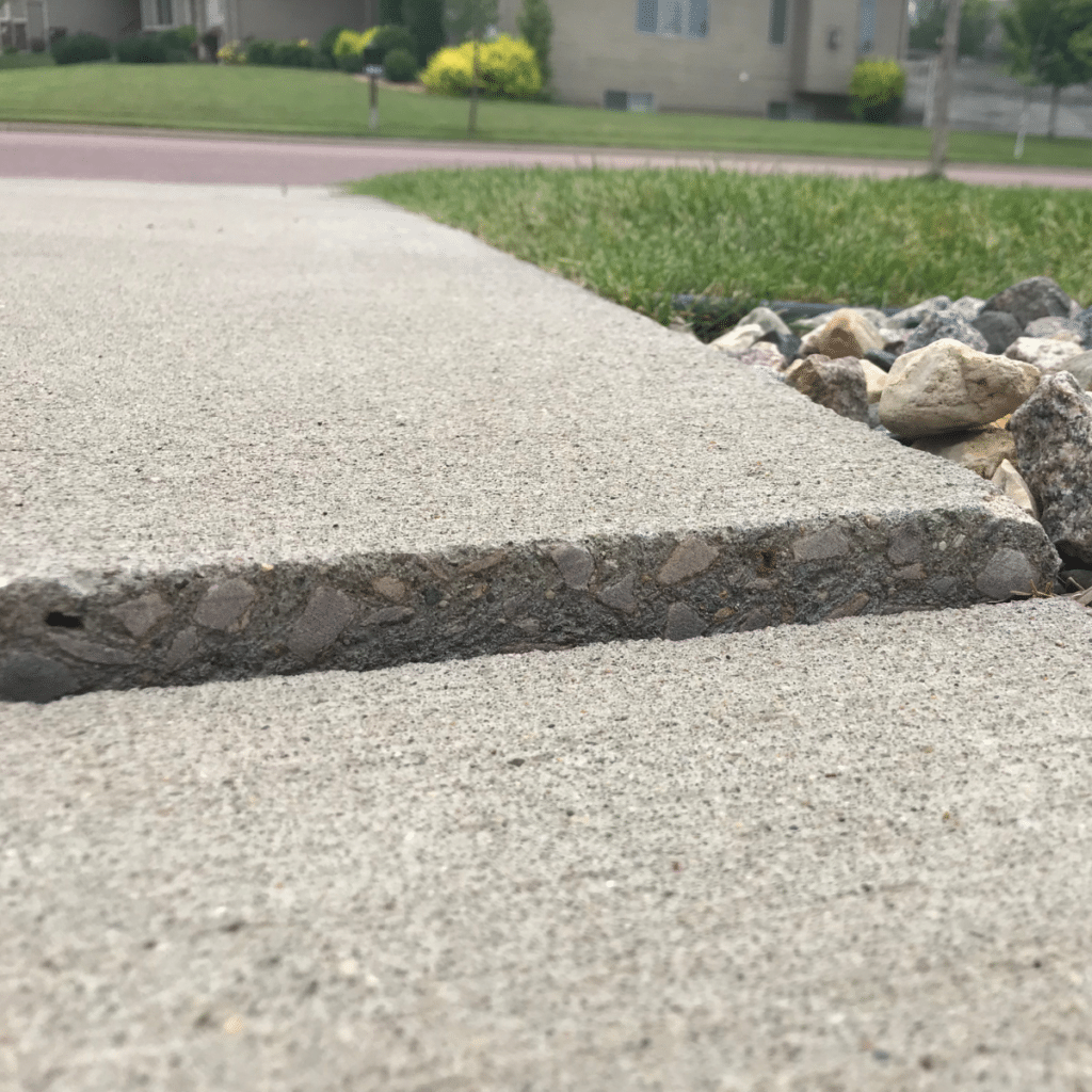 A raised section of a sidewalk with decorative rocks beside it