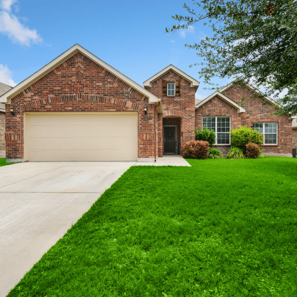 Brick single-family home with a two-car garage and a well-maintained lawn