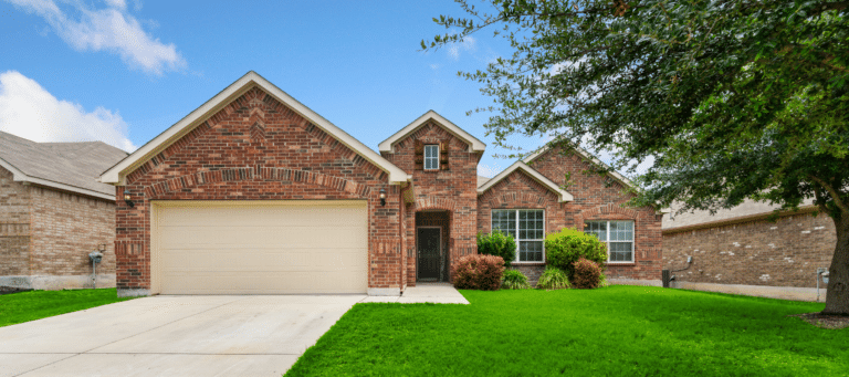 Brick single-family home with a two-car garage and a well-maintained lawn