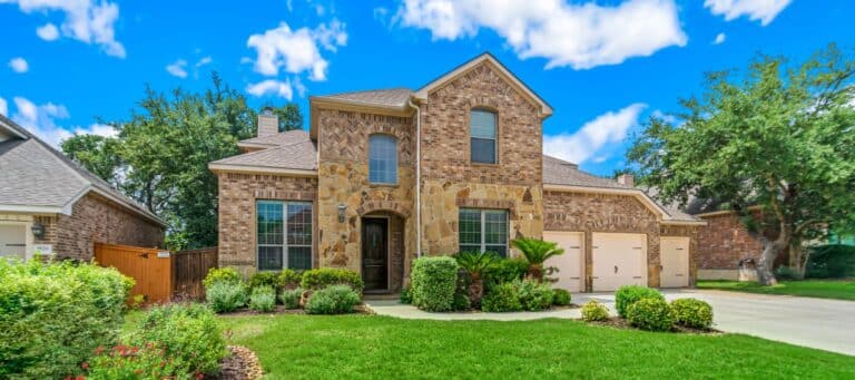 Traditional brick and stone suburban house with manicured landscaping and a spacious driveway