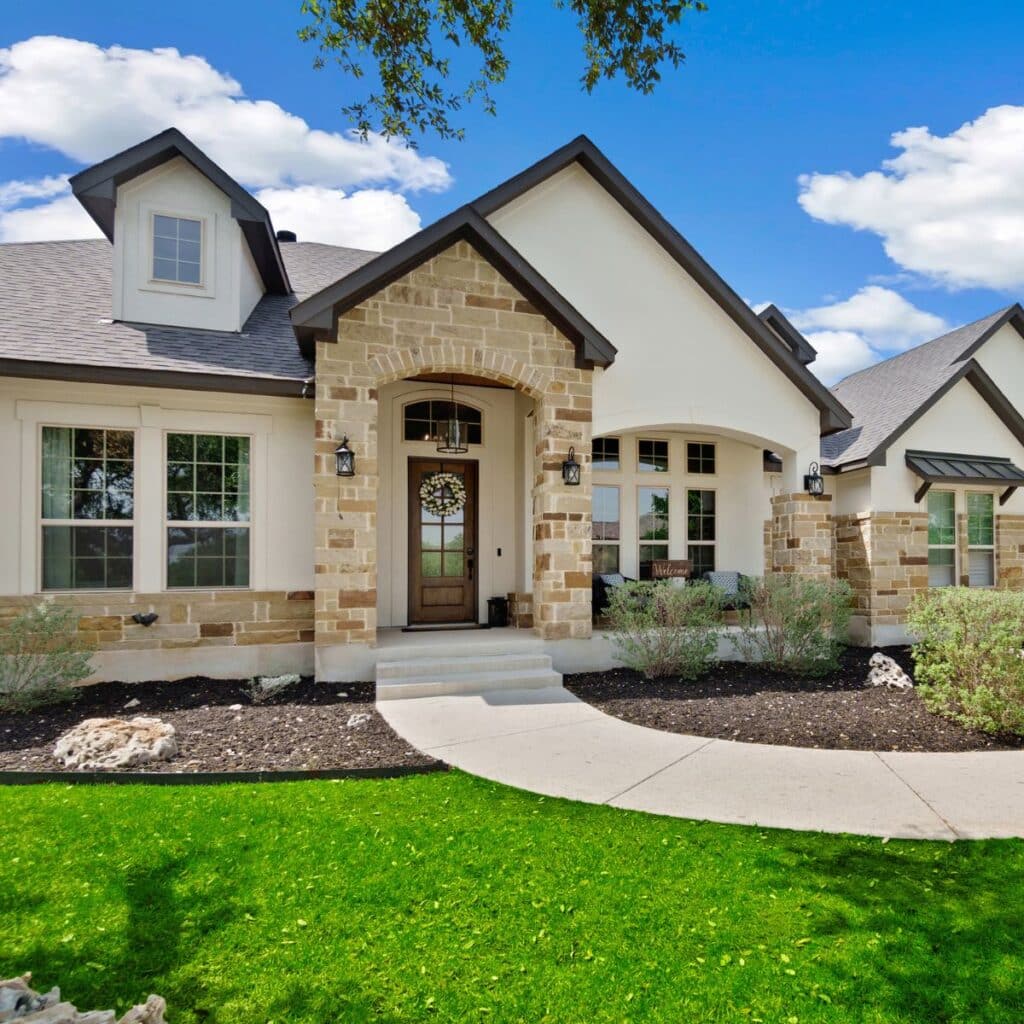 Modern Texas-style home with stone and stucco exterior and a curved walkway