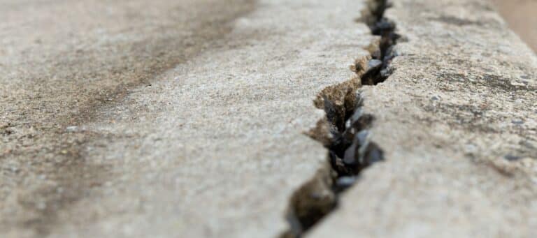 Close-up of a large crack in concrete pavement