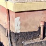 Exposed foundation wall showing excavation work for house leveling