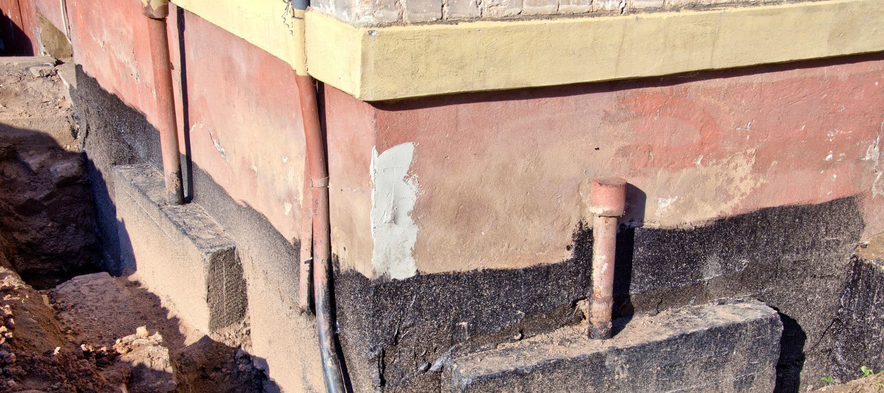 Exposed foundation wall showing excavation work for house leveling