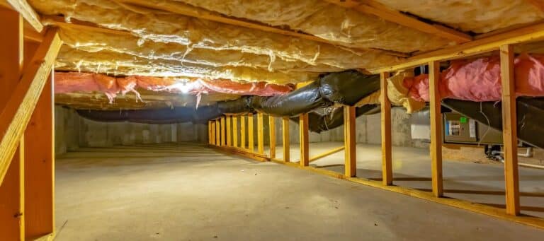 Crawl space with exposed insulation, ductwork, and wooden framing