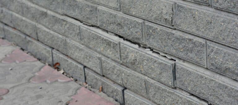 Brick wall foundation showing visible cracks and separation