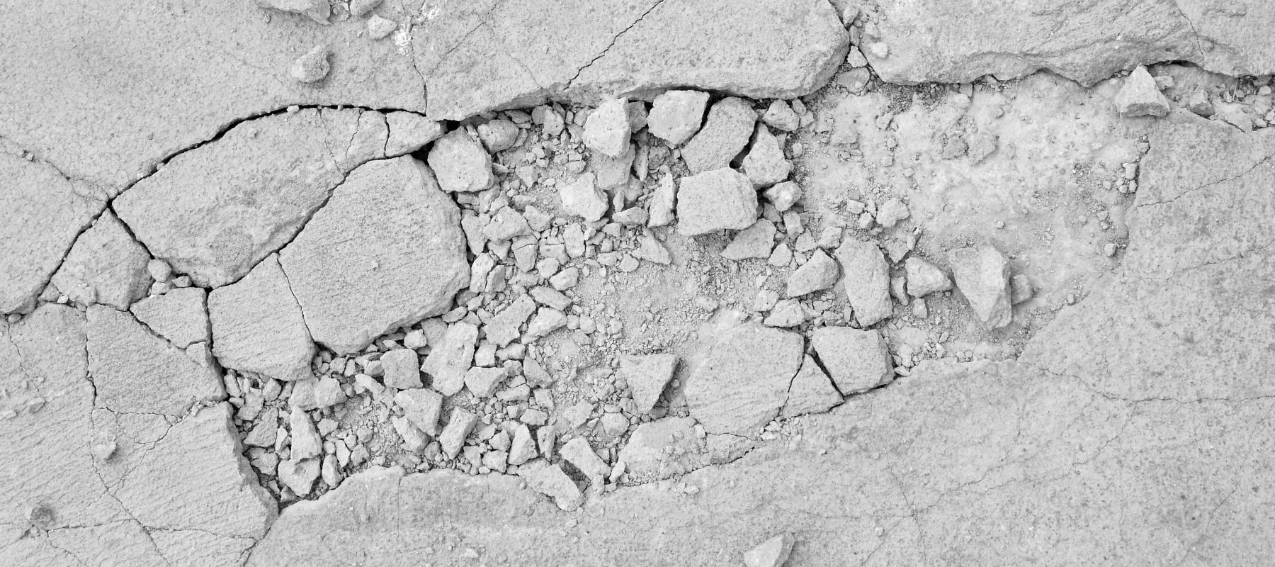 Close-up of cracked and broken concrete surface