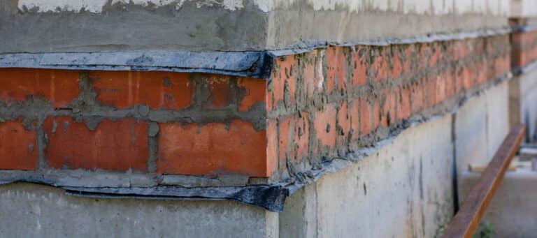 Close-up of brick foundation with visible mortar and repair work