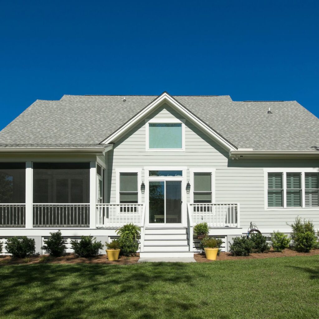 Front view of a pier and beam home with light siding and a small porch