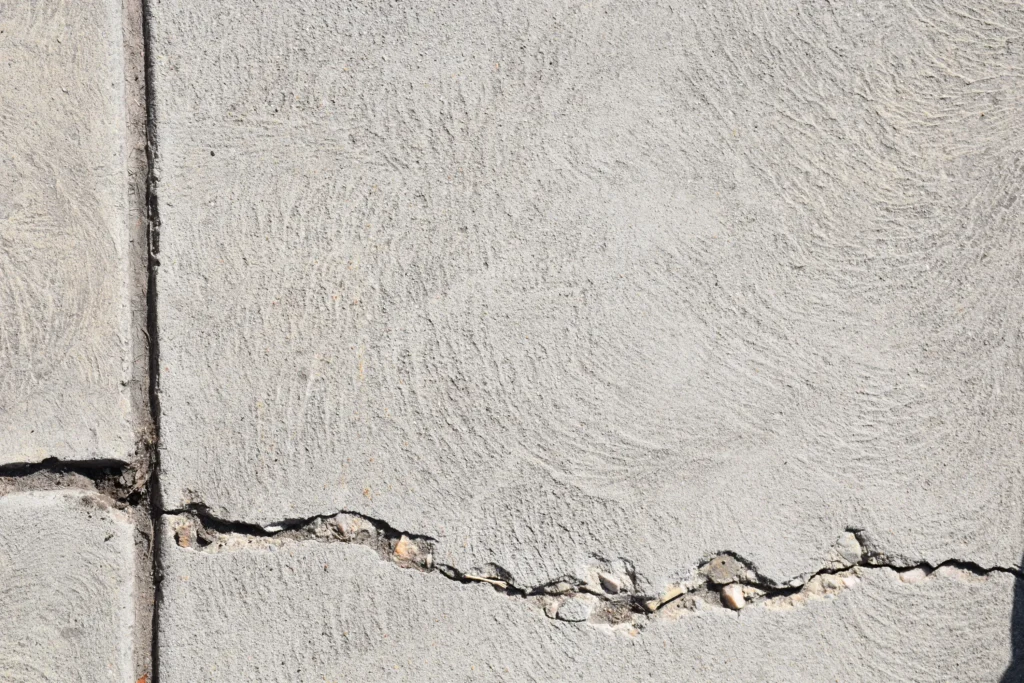 Close-up of a horizontal crack in a concrete foundation wall showing significant structural damage.