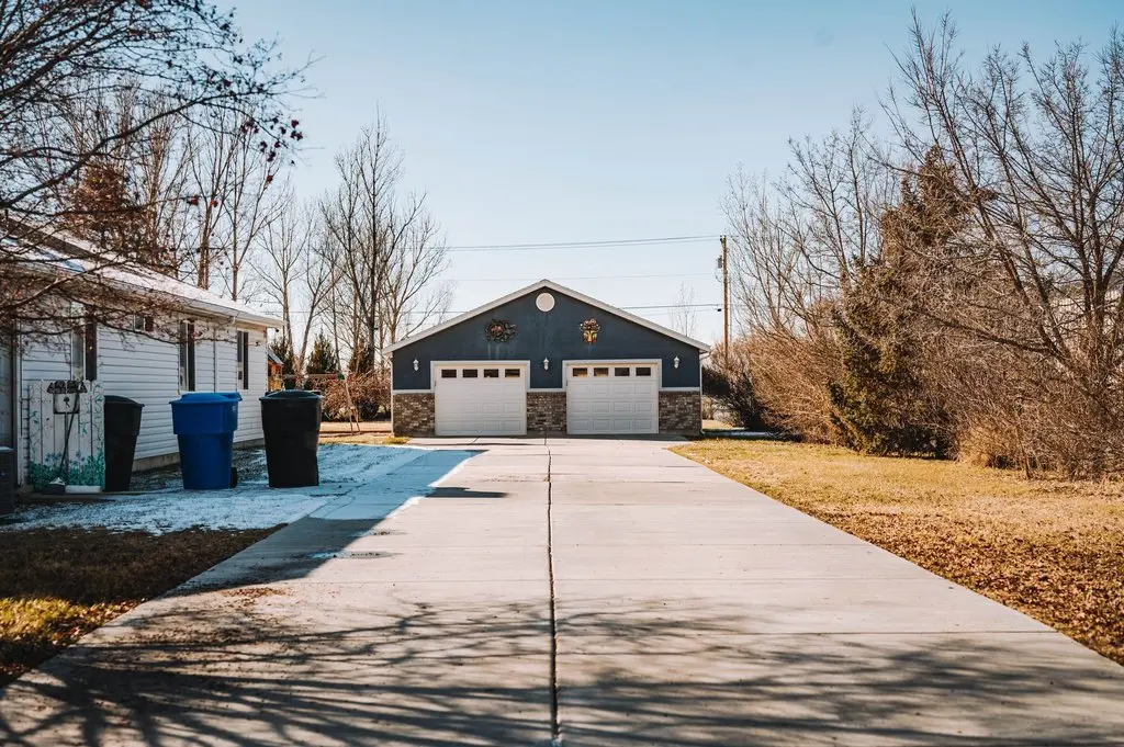 Finished concrete driveway leading to a Waco home with attached garage